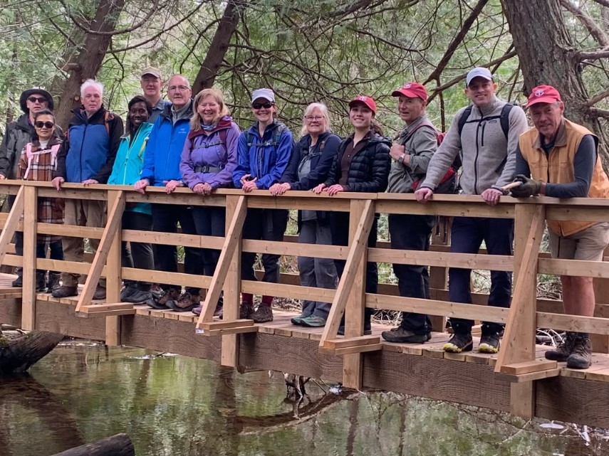 A picture showing the 2025 Toronto Bruce Trail Club Board of Directors standing together on a bridge on the trail.